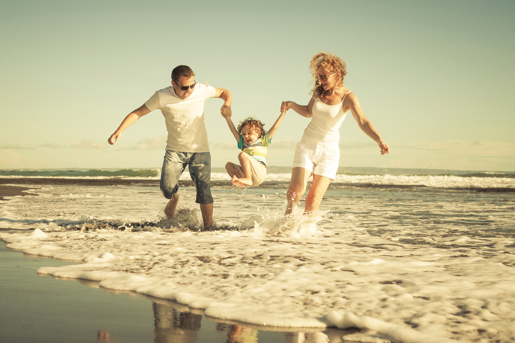 Szczęśliwa rodzina grająca na plaży